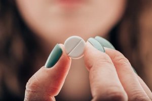 Woman holding a pill needs oxycodone addiction treatment